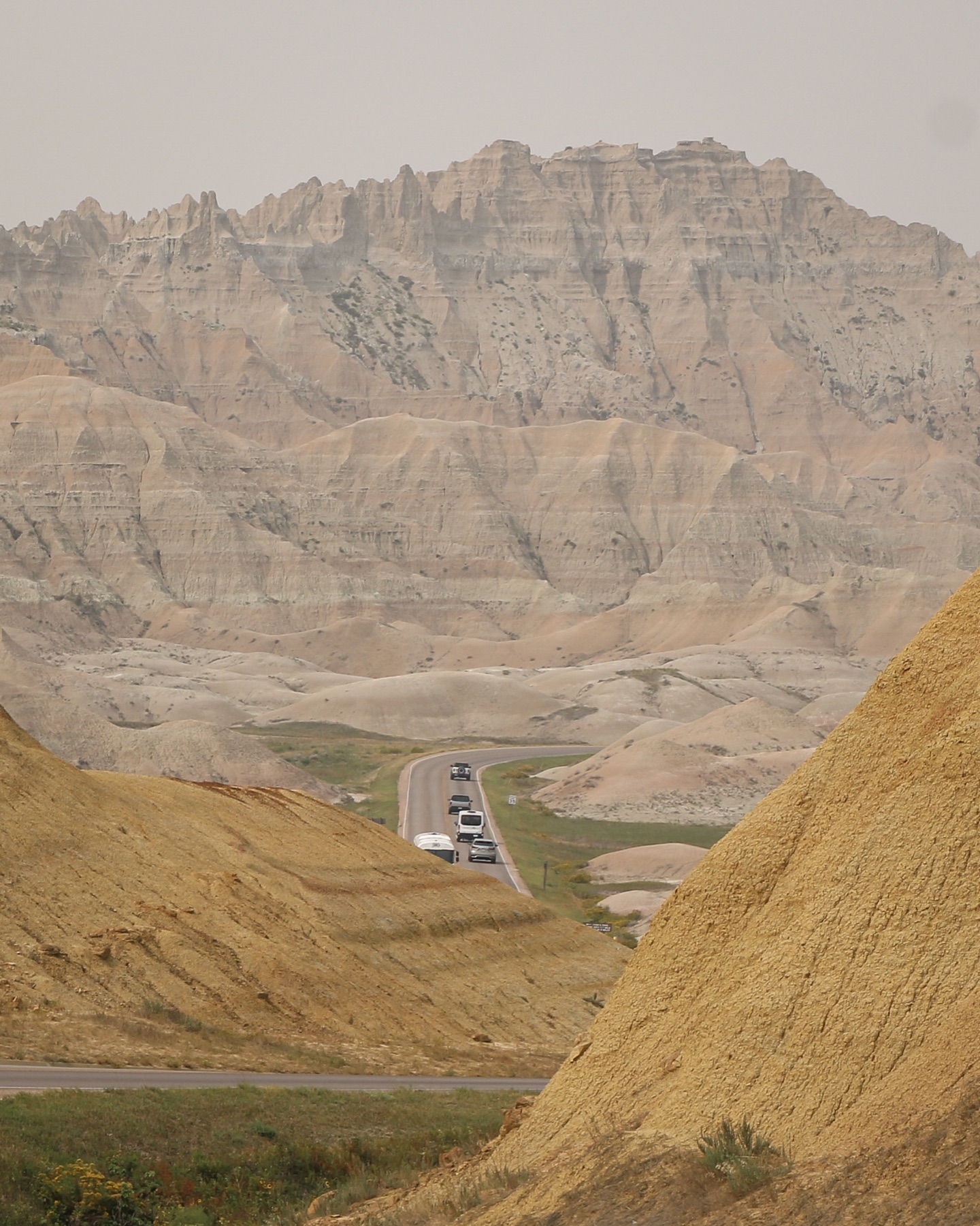 A winding road passing through the layered formations of Badlands National Park