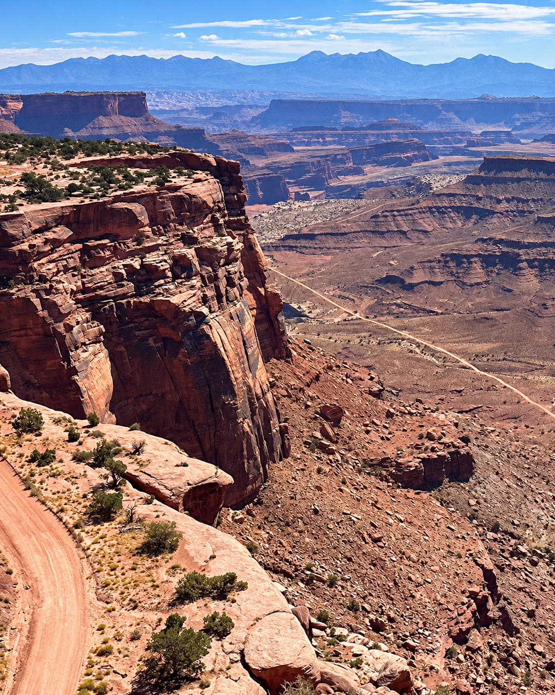 Canyon Rim Road overlooking layered cliffs and distant mountains