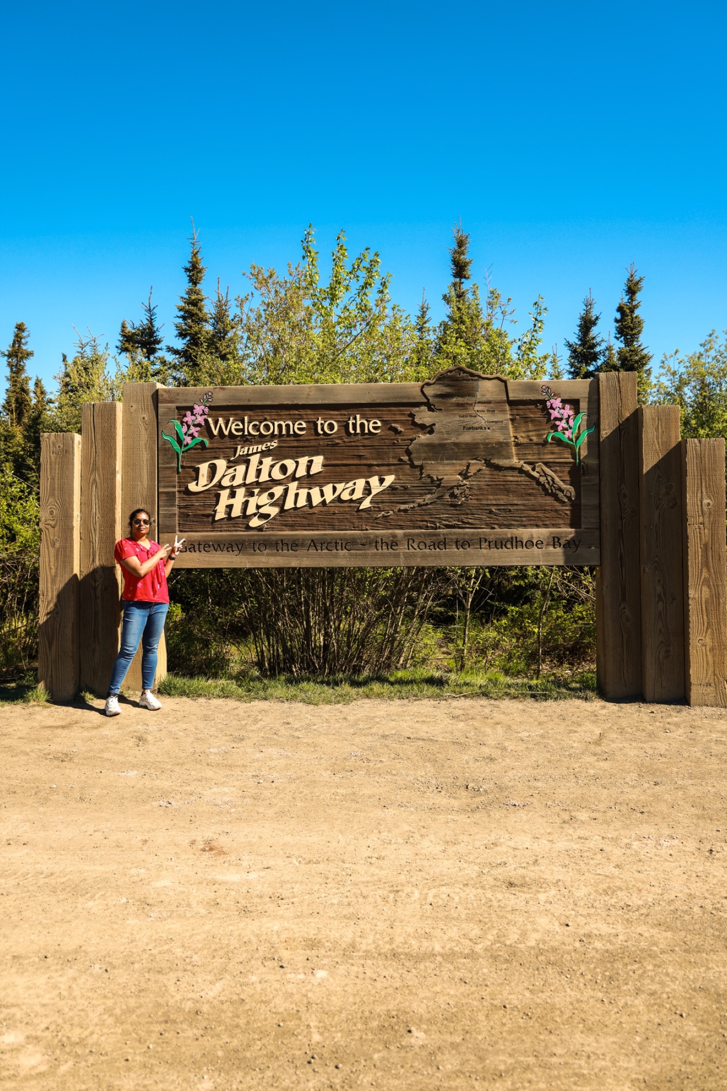 Traveler beside the welcome sign for the James Dalton Highway